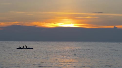 People Kayaking on the Ocean at Sunset