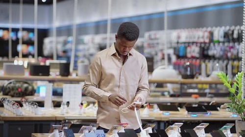 Afroamerican Man is Choosing Smartphone in Digital Equipment Store Portrait of Male Shopper in