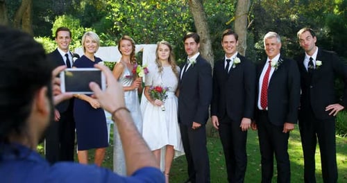 Photographer taking photo of bride and groom with there family 4K 4k