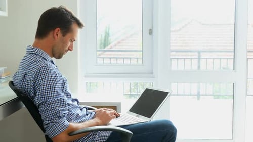 Man using laptop at home 4k