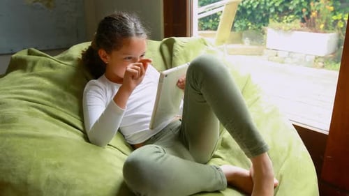 Girl Using Tablet on Beanbag at Home