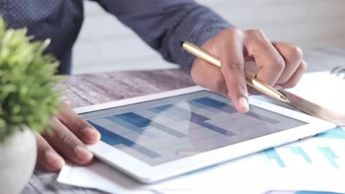 Young Man Analyzing Financial Diagram on Digital Tablet