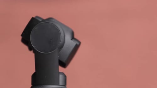 Camera Tilts Upright on Blurred Coral Background