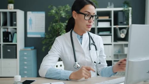 Professional Medic Giving Online Consultation From Hospital Office Using Laptop