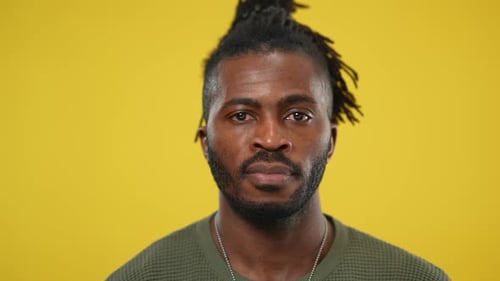 Smiling Man Wearing Green Shirt in Front of Yellow