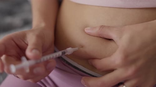 Adult Administers Injection into Abdomen