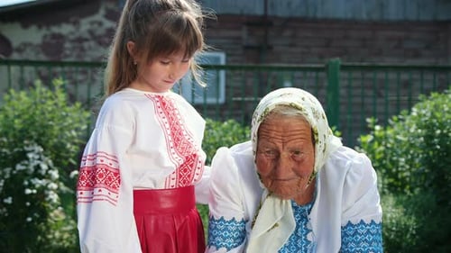 An Old Grandmother is Sitting on the Street and Reading a Book