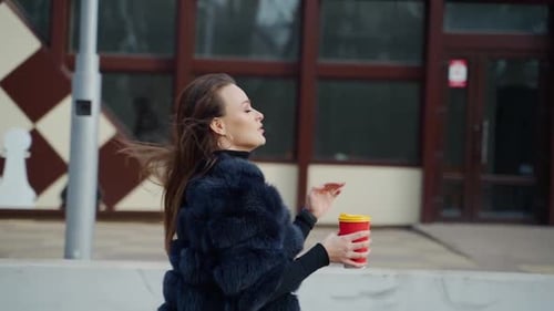 Beautiful sensual girl with dark hair wearing luxurious fur coat