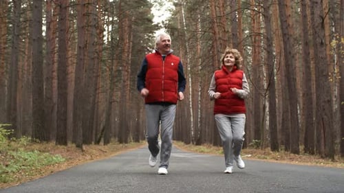 Aged Man and Woman Running in Forest
