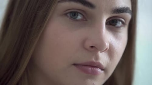 Portrait of Young Pretty Woman with Different Colored Eyes Looking at Camera in the Morning