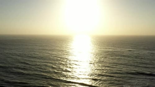 AERIAL Yellow Ocean Sunrise Over Blue Sky Dawn During Summer