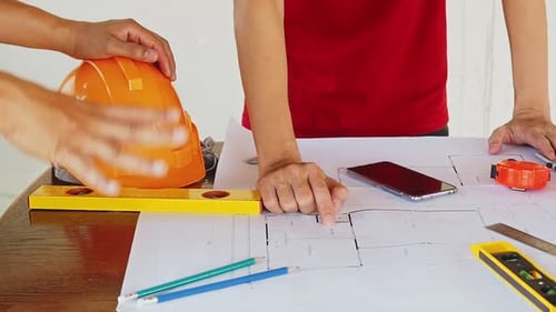 Engineers Reviewing Construction Blueprint Plans Together