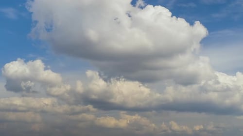 Zeitrafferaufnahmen von sich schnell bewegenden weißen geschwollenen Wolken auf blauem, klarem Himmel