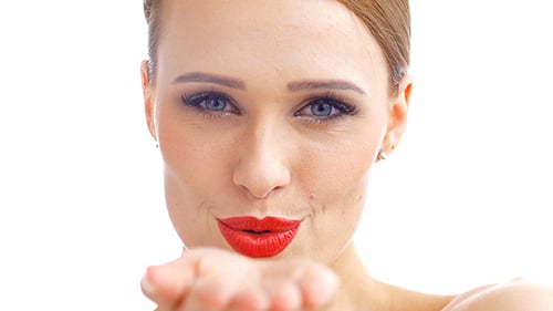 Glamorous Woman Smiles and Blows Kiss