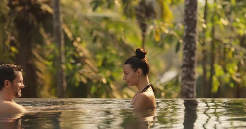 Couple in Love Together in Infinity Swimming Pool Outdoors During Tropical Vacation