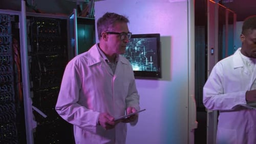 IT Specialists in Lab Coats Working in Data Center