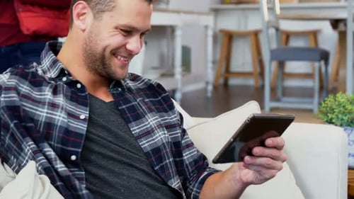 Happy Couple Relaxing at Home with Tablet