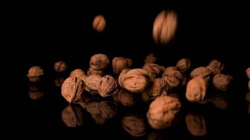 Walnuts Falling On Black Surface, English Shelled Walnuts, Close-Up