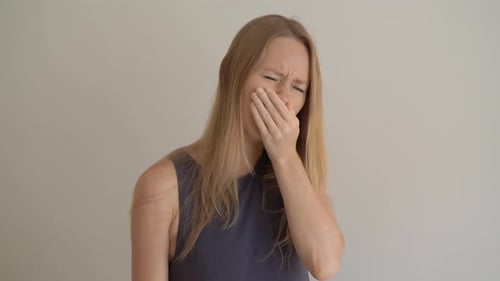 Une jeune femme éternue incorrectement
