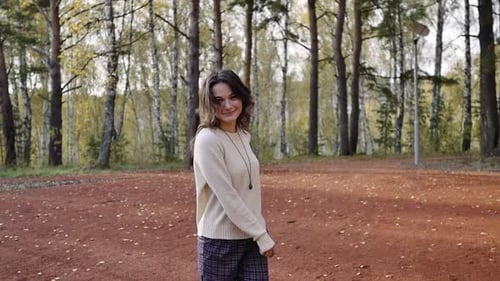 Eine junge Frau geht im Herbstpark spazieren. Brunette Frau springt und tanzt im Wald.
Freiheit