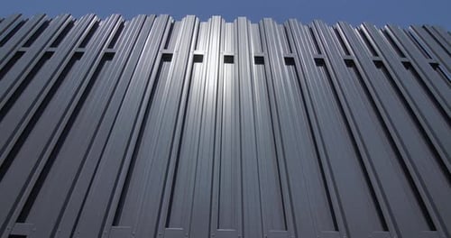 Modern Gray Metal Fence Under Clear Blue Sky