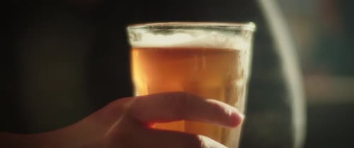 Hand Holding a Glass of Cold Beer
