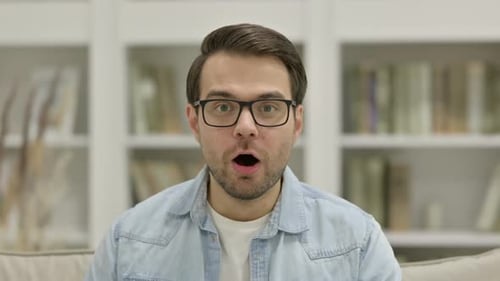 Man Reacts With Delight And Surprise Indoors