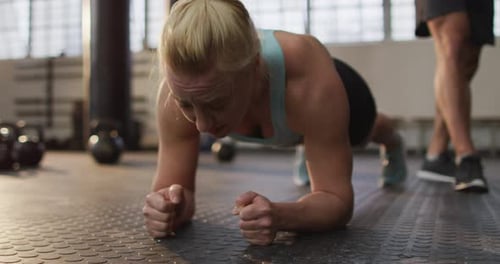 Close up of fit caucasian woman performing plank exercise at the gym