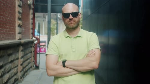 Bearded Bald Man Standing Confidently in Urban Alley