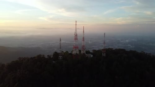 Aerial view fly away telecom tower at the peak