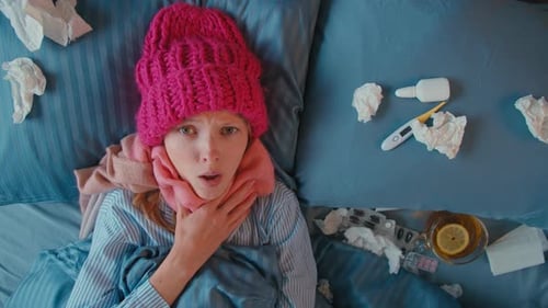 Sick Woman Lying in Bed with Cold and Flu