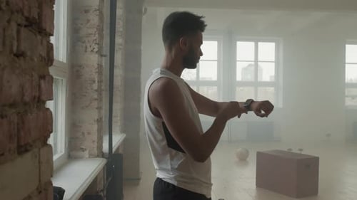 Man Checking Smart Watch in Gym Before Workout