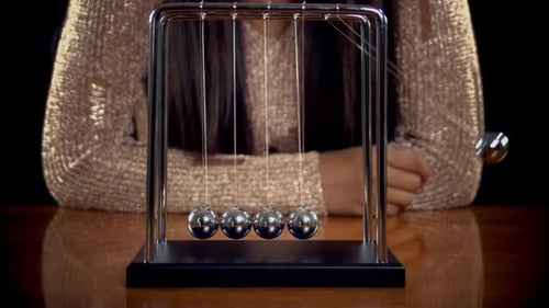Newton's Cradle Demonstrates Momentum With Shiny Silver Balls