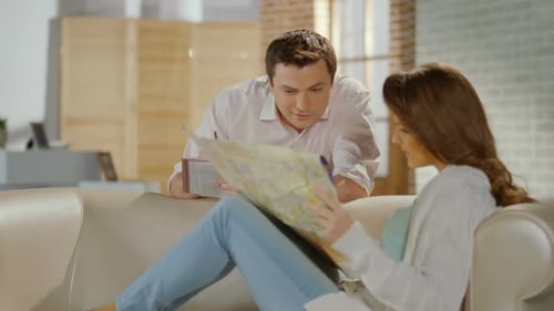 Feliz pareja de recién casados que planea un viaje de luna de miel, Comprobación del mapa
