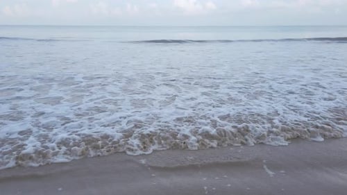 slow-motion natural sea wave water with foam on the sandy beauty white beach, summer beach seascape