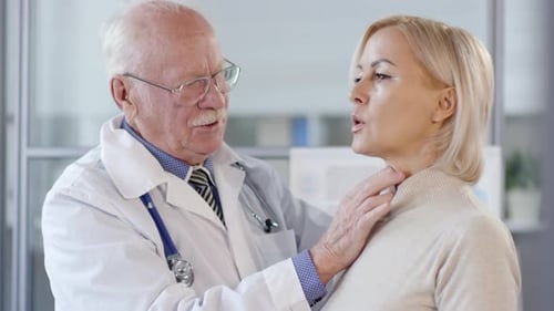 Senior Doctor Examines Woman Patient in Office