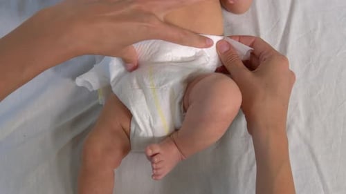 Caring Hands Changing Baby Diaper Overhead