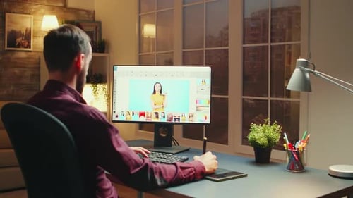 Man Retouching Images at Desk in Home Office