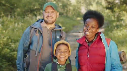 Smiling Family Hiking Together in Nature on Sunny Day