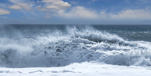 Ocean Waves Crashing on Shore Under Cloudy Sky