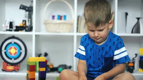Boy Plays with Building Blocks at Home