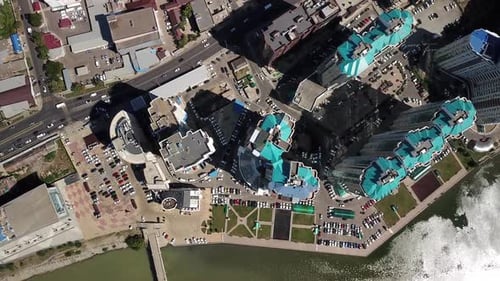 Aerial City View with Crossroads and Roads, Houses, Buildings, and Parking Lots.