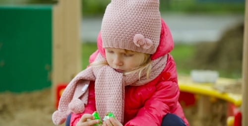 Girl Playing in the Sand at the Park