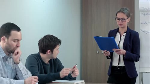 Woman Presenting to Male Coworkers in Office Meeting