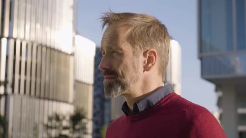A Middleaged Handsome Caucasian Man Looks Seriously at the Camera in an Urban Area