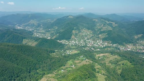 Aerial Drone View of a Township in a Mountain Valley Against a Blue Sky