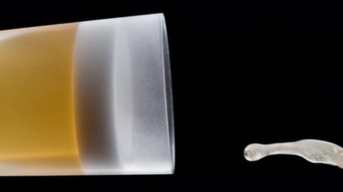 Close Up Pouring Foamy Drink into Glass