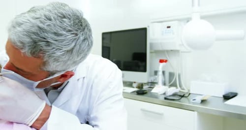 Dentista examinando a una paciente femenina con herramientas dentales