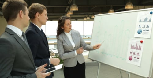 Corporate Team Meeting with Charts and Tablet