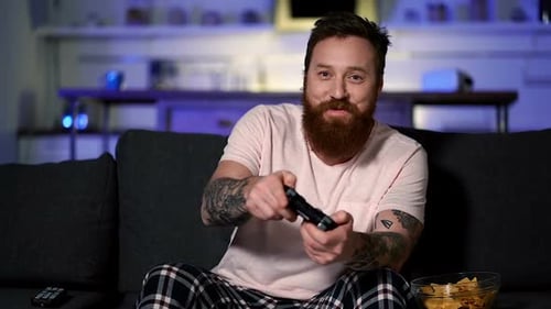 Bearded Adult Playing Video Game on Couch